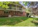 Inviting two-story brick home featuring charming balconies and a lush green lawn at 372 Vance St, Lakewood, CO 80226