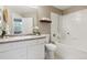 Bright bathroom with a white tub, shower, toilet, vanity, and a decorative shelf with towels and a plant at 12914 Ironstone Way # 102, Parker, CO 80134