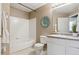 Bright bathroom with a white tub, shower, toilet, vanity, and decorative elements on the wall and counter at 12914 Ironstone Way # 102, Parker, CO 80134