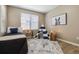 Bright bedroom featuring neutral walls, a bed, accent rug, and a play teepee tent by the window at 12914 Ironstone Way # 102, Parker, CO 80134