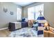 Bright bedroom featuring neutral walls, a bed, accent rug, and a play teepee tent by the window at 12914 Ironstone Way # 102, Parker, CO 80134