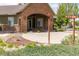Inviting covered front porch with brick archway and manicured landscaping at 12914 Ironstone Way # 102, Parker, CO 80134