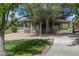 Exterior view of a community structure with a shaded patio, surrounded by mature trees and a sidewalk at 12914 Ironstone Way # 102, Parker, CO 80134