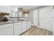 Kitchen featuring white cabinets, stainless steel sink, dishwasher, and hardwood floors at 12914 Ironstone Way # 102, Parker, CO 80134