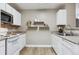 Kitchen featuring white cabinets, stainless steel microwave, and modern floating shelves at 12914 Ironstone Way # 102, Parker, CO 80134