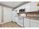 Kitchen with white cabinets and appliances, including a refrigerator, oven, and microwave at 12914 Ironstone Way # 102, Parker, CO 80134
