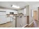 Well-lit kitchen featuring white cabinets, appliances, and a breakfast bar for casual dining at 12914 Ironstone Way # 102, Parker, CO 80134