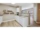 Kitchen with white cabinets, stainless steel sink, and a view into the living space at 12914 Ironstone Way # 102, Parker, CO 80134