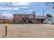 View of the back exterior featuring a brick facade and a large yard, deck, and entrance at 785 Planet Pl, Thornton, CO 80260