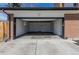 View of an attached garage with a freshly painted white interior and sealed concrete floors at 785 Planet Pl, Thornton, CO 80260