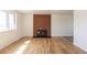 Bright living room with a brick fireplace and hardwood flooring at 785 Planet Pl, Thornton, CO 80260