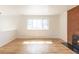 Bright living room featuring hardwood floors, a large window, and a fireplace at 785 Planet Pl, Thornton, CO 80260