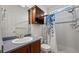 Compact bathroom with a walk-in shower, vanity with sink, toilet, and functional storage cabinet, maximizing space at 16823 Weber Way, Mead, CO 80542