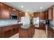Well-equipped kitchen with wooden cabinets, stainless steel appliances, granite countertops, and a central island for functionality at 16823 Weber Way, Mead, CO 80542