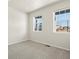 Bright bedroom with neutral carpet, white walls, and two windows allowing ample natural light at 9099 Pitkin St, Commerce City, CO 80022