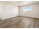A bright bedroom with wood-look floors and a large window overlooking an expansive outdoor view at 9099 Pitkin St, Commerce City, CO 80022