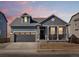 Charming two-story home with a gray exterior, stone accents, and a two-car garage at 9099 Pitkin St, Commerce City, CO 80022