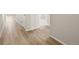 Inviting hallway with light wood-style flooring, neutral walls, and white trim at 9099 Pitkin St, Commerce City, CO 80022