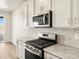 Modern kitchen featuring stainless steel appliances, granite countertops, and stylish backsplash at 9099 Pitkin St, Commerce City, CO 80022