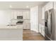 Contemporary kitchen with stainless appliances, island and sink, and hardwood flooring at 9099 Pitkin St, Commerce City, CO 80022