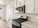 Modern kitchen featuring stainless steel appliances, granite countertops, and custom cabinets at 9099 Pitkin St, Commerce City, CO 80022