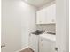 Clean laundry room with modern washer, dryer, cabinets and hardwood flooring at 9099 Pitkin St, Commerce City, CO 80022