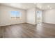 Bright living area with large window, wood-look floors, and sliding glass door to a balcony with a view at 9099 Pitkin St, Commerce City, CO 80022