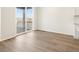 Bright room with a sliding glass door that leads to a balcony overlooking the plains and wood-look floors at 9099 Pitkin St, Commerce City, CO 80022
