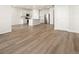 Spacious living area with open layout to the kitchen featuring white cabinets and stainless steel appliances at 9099 Pitkin St, Commerce City, CO 80022