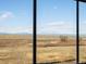 Expansive view of open fields and distant mountains from the home's large window at 9099 Pitkin St, Commerce City, CO 80022