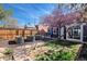 Landscaped backyard featuring garden beds, a black building, and a tree with pink blossoms at 328 S Lincoln St, Denver, CO 80209