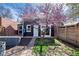 A backyard with a black home and blooming ornamental tree and a wooden fence at 328 S Lincoln St, Denver, CO 80209