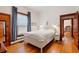 Bright bedroom with hardwood floors, white walls, and a large window with blue curtains at 328 S Lincoln St, Denver, CO 80209
