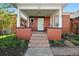 Charming red brick home featuring a covered front porch with an inviting entryway and well-manicured landscaping at 328 S Lincoln St, Denver, CO 80209