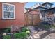 Landscaped side yard features a wooden gate, stone pathway, and lush greenery, adding charm and privacy at 328 S Lincoln St, Denver, CO 80209