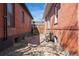 Side yard between brick homes, gravel path, and a wood fence at 328 S Lincoln St, Denver, CO 80209