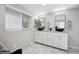 Bright bathroom with double sinks, large mirrors, and elegant white cabinetry at 3930 S Hazel Ct, Englewood, CO 80110