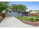 Neat front yard with green grass, a paved driveway, and an inviting exterior with garden bed at 3930 S Hazel Ct, Englewood, CO 80110