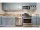 Well-equipped kitchen showcasing stainless steel appliances, granite countertops, and gray shaker cabinets at 3930 S Hazel Ct, Englewood, CO 80110