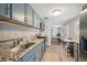 Modern kitchen featuring gray cabinets, stainless steel appliances, and a view into the living area at 3930 S Hazel Ct, Englewood, CO 80110