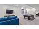 Spacious basement with a comfortable blue sofa, a large TV, and a pool table for entertainment at 3612 Wyandot St, Denver, CO 80211