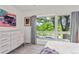 Sunlit bedroom with large windows offering serene tree views and a modern dresser at 3612 Wyandot St, Denver, CO 80211