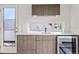 Contemporary wet bar featuring stone countertops, custom cabinets, and a beverage refrigerator at 3612 Wyandot St, Denver, CO 80211