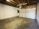 A garage with exposed rafters, cement floors, and a white garage door at 5344 Wheeling St, Denver, CO 80239