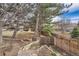 Backyard landscape design, with split rail fence, trees, and walkway at 17306 W 17Th Pl, Golden, CO 80401