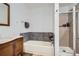 Bathroom featuring a shower and bathtub, complemented by stylish tiling and vanity at 17306 W 17Th Pl, Golden, CO 80401