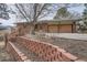 Exterior features a brick home, brick planter and mature trees in a landscaped yard at 17306 W 17Th Pl, Golden, CO 80401