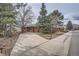 A wide exterior shot of a brick home with a large driveway and mature landscaping at 17306 W 17Th Pl, Golden, CO 80401