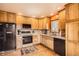 Bright kitchen featuring wooden cabinets, a black refrigerator, and wood flooring at 17306 W 17Th Pl, Golden, CO 80401