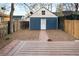 Backyard space with a deck, privacy fence, wood chips and a small building with a white door at 3142 W 26Th Ave, Denver, CO 80211